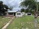Charming home exterior with front porch, a well-maintained lawn and detached garage at 111 D St, Frostproof, FL 33843