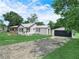 Features home, a detached garage, and long driveway surrounded by green lawn at 111 D St, Frostproof, FL 33843