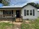 Charming exterior view features a front porch with wooden steps and railings and a freshly painted facade at 111 D St, Frostproof, FL 33843