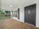 Charming front porch with wood decking, white columns, and a dark-stained front door at 111 D St, Frostproof, FL 33843