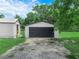 Detached garage featuring a black door and side door, with a driveway at 111 D St, Frostproof, FL 33843