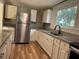 Bright kitchen with white cabinetry, granite countertops, and stainless steel refrigerator at 111 D St, Frostproof, FL 33843