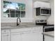 Close-up of the kitchen with granite counters, stainless appliances, and white cabinets at 111 D St, Frostproof, FL 33843