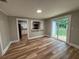 Light-filled living room with wood flooring, open kitchen view, and access to a backyard patio at 111 D St, Frostproof, FL 33843