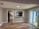Open-concept living room with wood flooring, bright light, and view to kitchen and backyard at 111 D St, Frostproof, FL 33843