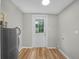 Bright utility room with a water heater, door to the backyard, and wood-look flooring at 111 D St, Frostproof, FL 33843