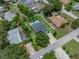 Aerial view showcases the home with a private pool, fenced yard, lush green grass, and mature trees at 1144 Cephia St, Lake Wales, FL 33853