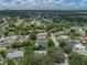 Aerial view of a neighborhood shows the home with an in-ground pool, green lawn, and fenced yard at 1144 Cephia St, Lake Wales, FL 33853
