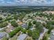 Aerial shot of neighborhood with tree-lined streets shows the home with a fenced yard and in-ground pool at 1144 Cephia St, Lake Wales, FL 33853
