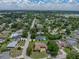 Aerial view of a tree-filled neighborhood shows the home with an in-ground pool, and fenced-in backyard at 1144 Cephia St, Lake Wales, FL 33853