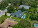 Home aerial view featuring a swimming pool, fenced yard, mature trees, and lush green grass at 1144 Cephia St, Lake Wales, FL 33853