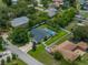 Aerial view of a home with a fenced backyard, green lawn, mature trees, and a sparkling blue swimming pool at 1144 Cephia St, Lake Wales, FL 33853
