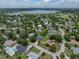 A wide aerial shot shows the home in a tree-filled neighborhood, with an in-ground pool, and nearby lake at 1144 Cephia St, Lake Wales, FL 33853