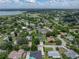 Wide aerial shot shows the home in a tree-filled neighborhood, with an in-ground pool, and nearby lake at 1144 Cephia St, Lake Wales, FL 33853