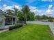 Spacious backyard with lush green grass, palms, and white privacy fence at 1144 Cephia St, Lake Wales, FL 33853