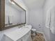 Cozy powder room with a framed mirror and a white vanity on tile floor at 1144 Cephia St, Lake Wales, FL 33853