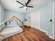 Light-filled bedroom features a playhouse bed, wood floors, and a bright blue wall at 1144 Cephia St, Lake Wales, FL 33853