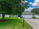 Charming home exterior with lush green lawn, mature tree, paved driveway, and a two-car garage at 1144 Cephia St, Lake Wales, FL 33853