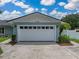 Garage features a white door with transom windows and exterior lighting, enhancing curb appeal at 1144 Cephia St, Lake Wales, FL 33853