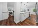 Open kitchen boasts white cabinets, stainless appliances, and an island with pendant lighting at 1144 Cephia St, Lake Wales, FL 33853