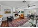 Charming living room with a brick fireplace, adjacent to a dining area, and featuring a decorative rug and comfortable seating at 1144 Cephia St, Lake Wales, FL 33853
