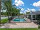 Backyard pool with brick pavers, black safety fence, and palm trees at 1144 Cephia St, Lake Wales, FL 33853