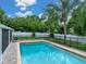 Beautiful pool surrounded by green backyard and black safety fencing at 1144 Cephia St, Lake Wales, FL 33853