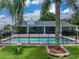 A refreshing in-ground pool featuring a safety fence for , perfect for summer fun, is surrounded by green grass at 1144 Cephia St, Lake Wales, FL 33853