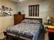 Cozy bedroom featuring a bed with patterned linens, dresser, and a window with wooden blinds at 1422 Avenue H Sw, Winter Haven, FL 33880