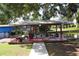 A covered boat dock featuring wooden deck, seating, and boat lift on a serene canal with mature trees at 1422 Avenue H Sw, Winter Haven, FL 33880