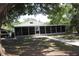 The exterior of the property shows a large screened-in porch, carport, walkway, and well-kept yard at 1422 Avenue H Sw, Winter Haven, FL 33880