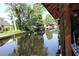 Tranquil waterfront view featuring lush trees, a wooden dock, and peaceful canal at 1422 Avenue H Sw, Winter Haven, FL 33880