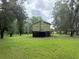 Exterior view of the home with a large yard and trees surrounding the property at 1885 Pfundstein Rd, Babson Park, FL 33827