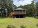 Scenic elevated home with a screened porch, nestled in a serene, tree-filled environment at 1885 Pfundstein Rd, Babson Park, FL 33827