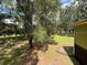 Back exterior view of the home and a large yard surrounded by many trees at 1885 Pfundstein Rd, Babson Park, FL 33827