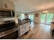 Open kitchen featuring stainless appliances, wood floors and a center island at 1885 Pfundstein Rd, Babson Park, FL 33827