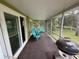 Relaxing screened porch with comfortable blue chairs, grill and views of the outdoors at 1885 Pfundstein Rd, Babson Park, FL 33827