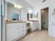 Well-lit bathroom with double vanities, granite countertops, and a glass-enclosed shower at 2200 Mallory Cir, Haines City, FL 33844
