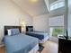 Bright bedroom features two twin beds, a vaulted ceiling, and a large window with blinds at 2200 Mallory Cir, Haines City, FL 33844