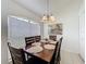 Cozy dining area with a wooden table, six chairs, tile flooring, and natural light from a large window at 2200 Mallory Cir, Haines City, FL 33844