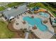 Aerial view of community pool, splash pad, and playground with clubhouse in the background at 2655 Swooping Sparrow Dr, Harmony, FL 34773