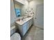 Bathroom with double sinks, white cabinets and tile flooring at 2655 Swooping Sparrow Dr, Harmony, FL 34773