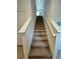 Carpeted staircase with white banister, leading to the upper level of the house with natural light at 2655 Swooping Sparrow Dr, Harmony, FL 34773