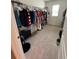 Spacious walk-in closet with organized clothing racks and neutral carpeting at 2655 Swooping Sparrow Dr, Harmony, FL 34773