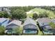 A view of three homes with screened-in pools overlooking the golf course in a quiet, landscaped neighborhood at 2692 Hemingway Ave, Haines City, FL 33844