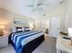 Bedroom with an ensuite bathroom, ceiling fan, and comfortable neutral carpeting for a relaxing experience at 2692 Hemingway Ave, Haines City, FL 33844