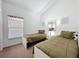Cozy bedroom featuring neutral decor, twin beds, and soft natural light from the window at 2692 Hemingway Ave, Haines City, FL 33844