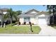 Charming single-story home with well-manicured landscaping, a palm tree, and an attached two car garage at 2692 Hemingway Ave, Haines City, FL 33844