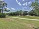 Scenic view of the lush green golf course surrounded by mature trees and clear blue skies at 2692 Hemingway Ave, Haines City, FL 33844