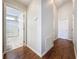 Hallway with wood floors leads to a bright bathroom featuring shower and bath at 2692 Hemingway Ave, Haines City, FL 33844